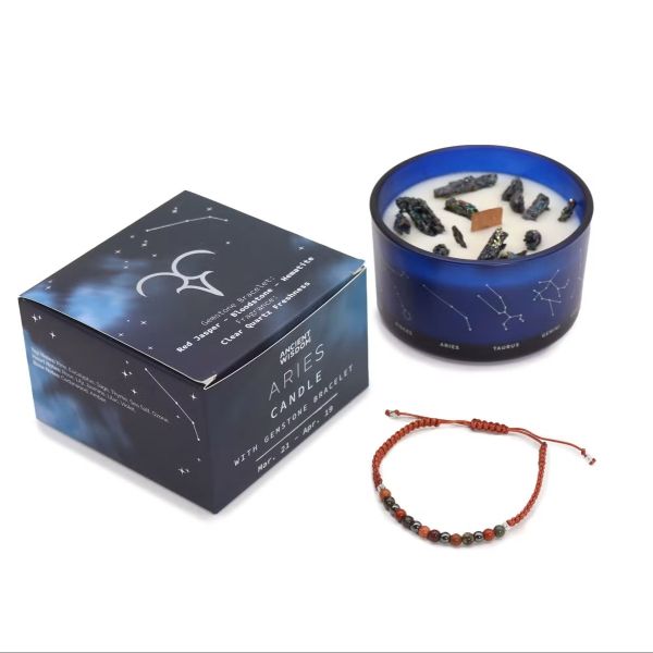Aries Zodiac Crystal Candle in dark blue glass jar with constellation design, shown with gemstone bracelet and gift box on a white background.