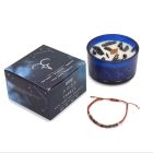 Aries Zodiac Crystal Candle in dark blue glass jar with constellation design, shown with gemstone bracelet and gift box on a white background.